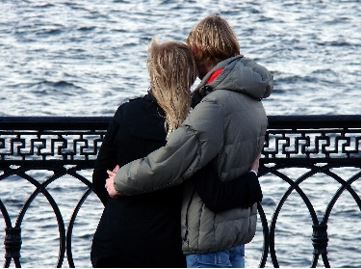 Un couple s’étreignant au bord de l’eau