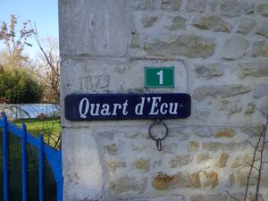 Un quart d'écu, ça fait combien en euros ? Que lit le passant, gravé dans la pierre ? 