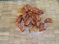 1 - Peler les crevettes roses et grises. Oter la peau du chorizo, le découper en petits morceaux. Laver et ciseler les brins de ciboulette. Peler l'ail.