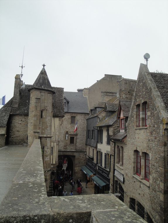 La cuisine de la Mère Poulard, là où l'on prépare la fameuse omelette, une vue sur la salle à manger, au mur les photos des célébrités qui ont fréquenté le lieu, puis maisons, rues et enseignes.