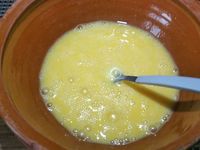 2 - Frotter les tranches de pain de mie avec l'ail. Les couper en diagonale pour obtenir des triangles, et les badigeonner au pinceau avec de l'huile d'olive (ou du beurre fondu).Disposer les tranches de pain de mie sur une plaque allant au four recouverte de papier sulfurisé, parsemer un peu de piment d'Espelette et passer au grill du four pendant quelques instants pour les dorer. Pendant ce temps battre les 4 oeufs en omelette, saler et poivrer légèrement.