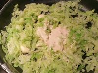 3 - Peler et écraser la gousse d'ail avec le plat d'un couteau. Faire revenir l'ail dans une poêle avec le beurre, rajouter le chou égoutté et laisser étuver à couvert, puis incorporer la moitié de la sauce à la crème, rectifier l'assaisonnement si besoin . Remettre le four à préchauffer th 6 (180°). Découper les pommes de terre en rondelles de 2 à 3 mm d'épaisseur, tailler la saucisse en rondelles de la même façon. Remettre le cercle autour de la pâte, étaler une couche de chou en tassant un peu, ôter le cercle et disposer les rondelles de saucisse, puis celles de pommes de terre au centre. Enfourner le tout pour 10 mn environ th 6 (180°). Déguster dès la sortie du four en rajoutant un peu de sauce au centre de la tarte fine pour un bel effet visuel.