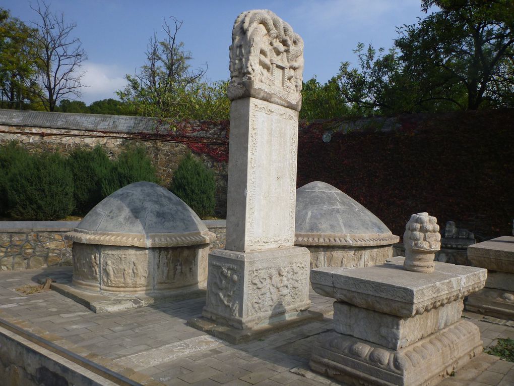 En visitant le tombeau de Tian Yi : le monticule de Tian Yi, au centre n'est pas décoré ; ceux des quatre autres eunuques, sur les côtés sont plus petits mais ornés de bas-reliefs.