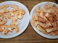 2 - Faire cuire les gambas dans une casserole d'eau bouillante. Les décortiquer en conservant les carcasses et les têtes pour réaliser un fumet, inciser le dos des gambas pour ôter le boyau central. Peler et émincer les oignons. Faire revenir dans une casserole avec un fond d'huile d'olive (2 cuil.) la moitié des oignons émincés. Rajouter les têtes et carcasses de gambas, les écraser un peu avec une spatule en bois pour faire ressortir les sucs, saler, poivrer, recouvrir d'eau à hauteur et laisser réduire sur feu doux 10 à 15 mn. Pendant ce temps, peler et dégermer l'ail et l'échalote et les émincer.