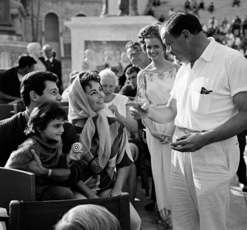 On the set of Cleopatra, in Rome: Liza Todd, a well-behaved little girl, shakes hand with the Director of the movie, Joseph Mankiewicz. The boys Michael and Christopher are impressed by the boss of their mother -  Joseph Mankiewicz chats with Elizabeth Taylor and Eddie Fisher, while Liza is seated on her stepfather's lap.