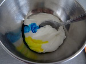 Pendant ce temps, réalisez votre glaçage, la divisée en 2, puis dans un des bol versez 2 gouttes de colorant bleu et 4 gouttes de colorant jaune. Ajustez à votre convenance selon si vous la voulez plus foncée et plus claire.