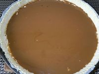 3 - Etaler la pâte feuilletée et la piquer à la fourchette. Disposer sur le fond de tarte la préparation à la noix, égaliser, puis étaler en couche la préparation à la crème de café. Enfourner la tarte pour une vingtaine de minutes environ. Pendant le temps de cuisson préparer la garniture en mélangeant dans un récipient les noix grossièrement concassées, la confiture de lait et un jaune d'oeuf. Au bout de 20 mn de cuisson, sortir la tarte du four, répartir sur le dessus la garniture aux noix concassées et enfourner à nouveau pour 7 à 8 mn environ en surveillant. La pâte doit finir de bien gonfler et dorer.