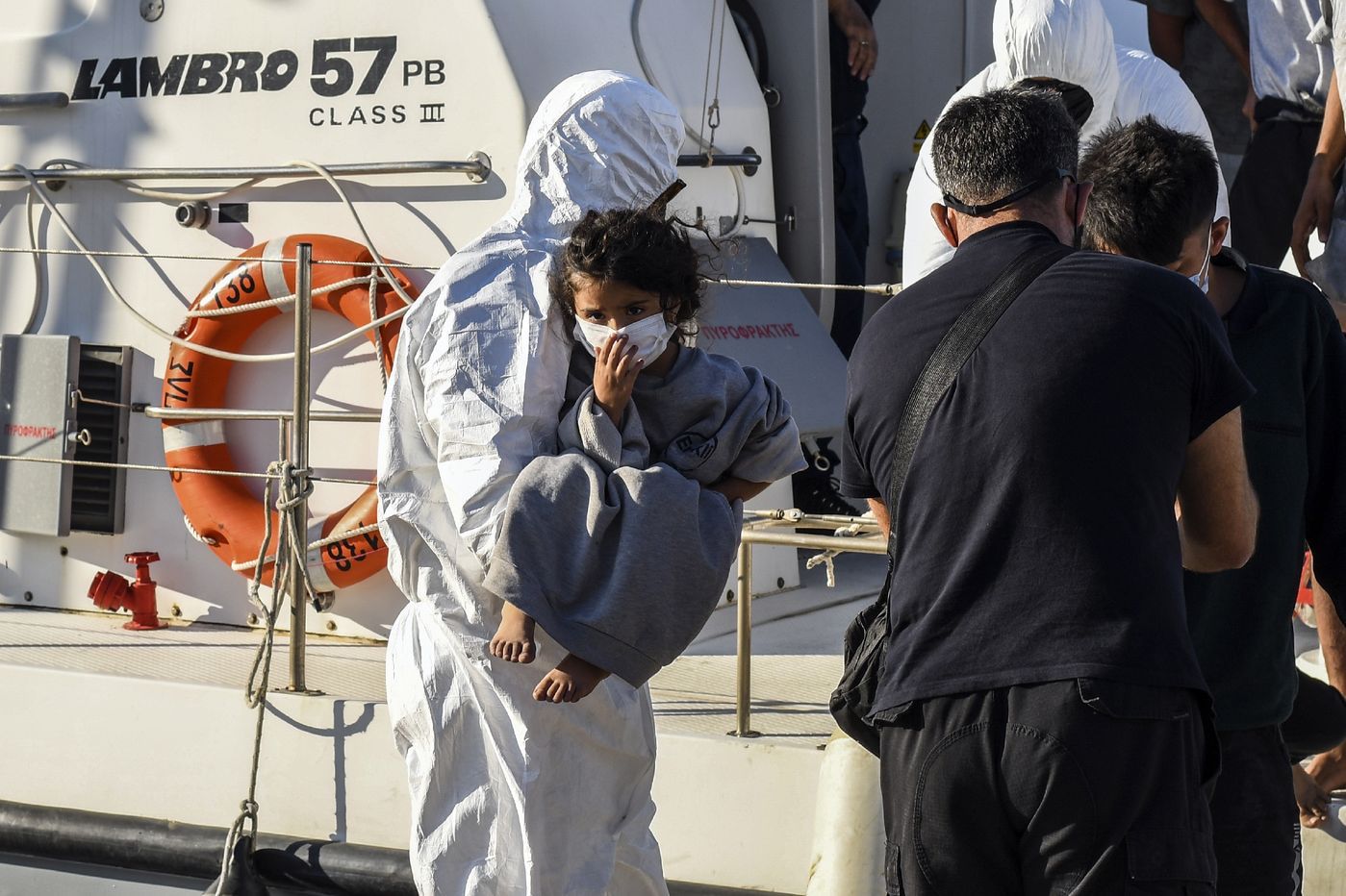 Des réfugiés et des migrants secourus débarquent d'un navire des garde-côtes grecs dans le port d'Ierapetra, sur l'île de Crète, le 23 juillet 2021 / AFP/Archives
