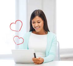 femme assis devant un ordinateur avec des coeurs rouge