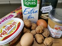 1 - Battre l'oeuf en omelette et réserver. Casser les noix et les passer au mixeur pour les réduire en poudre. Ecraser le beurre à la fourchette pour en obtenir une pommade. Incorporer le sucre, la poudre de noix, la moitié de l'oeuf battu et bien mélanger. Réserver cette préparation.