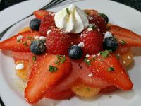 2 - Disposez sur une belle assiette à dessert, une fleur de pastèque, puis les petits disques de melon comme indiqué sur la photo. Recouvrez d'une deuxième fleur de pastèque. Placez les lamelles de fraises en étoile. Décorez le centre de framboises et myrtilles. Placez au réfrigérateur. Au moment de servir, posez une petite meringue sur votre dessert de fruits frais. Emiettez-en une autre sur la fleur étoilée, et parsemez de menthe ciselée et de zestes de combava. 