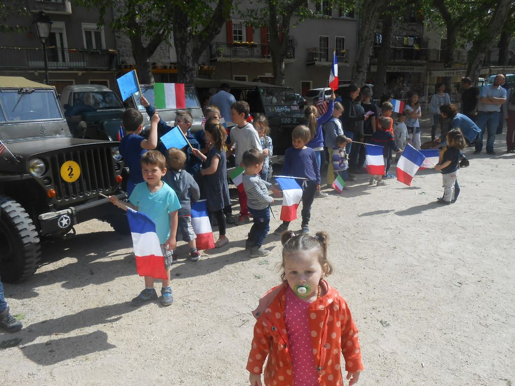 Les enfants descendent des voitures et se placent devant le monument aux morts