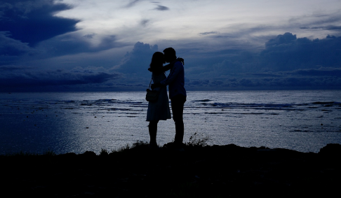 Un couple enlacé devant l’océan