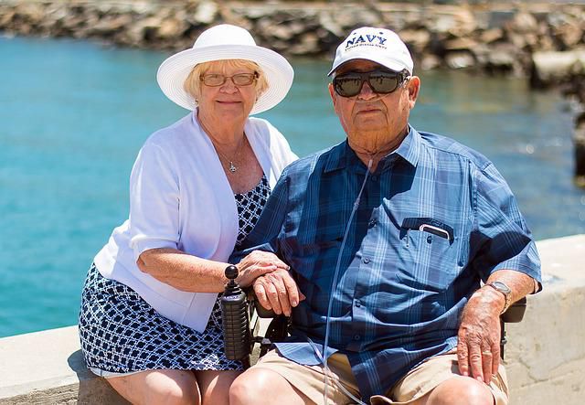 Un couple âgé assis près d’un étang d’eau