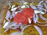 1 - Eplucher et couper l'oignon rouge en lamelles. Peler, dégermer l'ail et couper. Laver le thym et le romarin. Dans un plat en verre, mélanger les huiles, le vinaigre, ajouter l'oignon et l'ail émincés, la pulpe de tomate, les herbes (thym, romarin), le paprika doux, le piment d'Espelette et le sel. Déposer les tranches de poitrine de porc dans le plat, les retourner, couvrir d'un film étirable et réserver au réfrigérateur pour 3 h. Au bout des 3 h sortir du frigo, retourner les tranches sur l'autre face et mettre à nouveau au réfrigérateur pour 3 h.