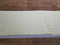 2 - Mettre le four à préchauffer th 6 (180°). Badigeonner le filet mignon de moutarde sur toutes les faces. Etaler la pâte feuilletée rectangulaire, en couper une partie pour la décoration. Disposer les tranches de lard fumé en les faisant se chevaucher. Répartir au milieu des tranches la moitié de la préparation aux champignons et échalotes comme sur la photo. déposer le filet mignon bien au centre, répartir le reste de champignons dessus et l'envelopper en venant rabattre la pâte autour. Bien souder les bords, retourner le filet mignon en croûte de façon à ce que les bords soudés se retrouvent en dessous. Passer un rouleau à losanges sur le rectangle de pâte réservé précédemment (ou découper de fines bandes si vous n'avez pas d'ustensile spécifique) pour réaliser un décor en croisillons à déposer sur le dessus de la pâte. Dorer le tout avec le jaune d'oeuf délayé dans un peu d'eau. Faire 3 à 4 trous dans la pâte et enfourner pour 30 à 40 mn th 6 (180°). 