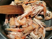 2 - Garder les têtes et les pattes des langoustines pour réaliser une bisque. Peler les échalotes et les gousses d'ail et les dégermer. Dans une casserole faire revenir dans un filet d'huile d'olive les carcasses de langoustines. Bien les écraser avec une spatule en bois pour faire ressortir le jus et permettre aux arômes de se libérer, laisser cuire 10 mn en remuant. Ajouter ensuite les échalotes, l'ail, le bouquet garni, laisser cuire 3 mn jusqu'à coloration. Incorporer ensuite la purée de tomates, et le concentré de tomates, mélanger et laisser fondre 2 mn. Couvrir enfin d'eau à hauteur, et laisser mijoter pendant 30 à 40 mn à feu doux.