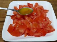 2 - Une fois le temps de marinade écoulé, sortir les tranches du réfrigérateur, les égoutter, les disposer sur une plaque allant au four recouverte de papier alu et les passer au grill du four 5 à 6 mn sur chaque face (selon les fours et l'épaisseur des tranches). Vous pouvez également les faire griller au barbecue ou à la plancha. Pendant la cuisson, préparer une petite salade de tomate en  lavant, séchant des tomates rouges, les couper en quartiers, les épépiner et les assaisonner avec un peu d'huile de marinade et du persil haché, saler et poivrer.  Servir en accompagnement des tranches de poitrine grillées.