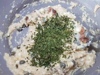 3 - Incorporer les anchois à la farce, puis le persil haché. Couper la base des tomates pour qu'elles soient bien stables. Les garnir avec la farce, terminer par déposer un câpre sur le dessus et recouvrir du chapeau avec le pédoncule.  Disposer sur un plat de service décoré suivant votre inspiration et proposer en petites bouchées à l'apéritif ou en entrée.