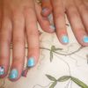Nail art degradé de bleu avec dessin de fleur 