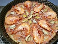 4 - Sortir du four. Garnir la pâte de purée de tomates fraîches, de gambas, de moules, crevettes grises, de dés de mozzarella et de câpres. Repasser la pizza au four pour 5 mn environ. Servir et déguster de suite !