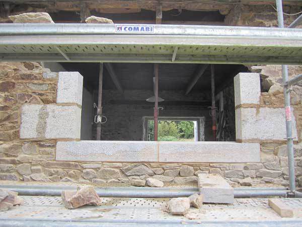 Piquage de l'enduit ciment intérieur, percement du mur et pose d'une fenêtre en pierres de taille avec arrières linteaux en chêne et tablette intérieure en granit