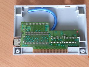 Travail d'intégration d'un connecteur USB femelle dans une cartouche de jeu Super Nintendo.