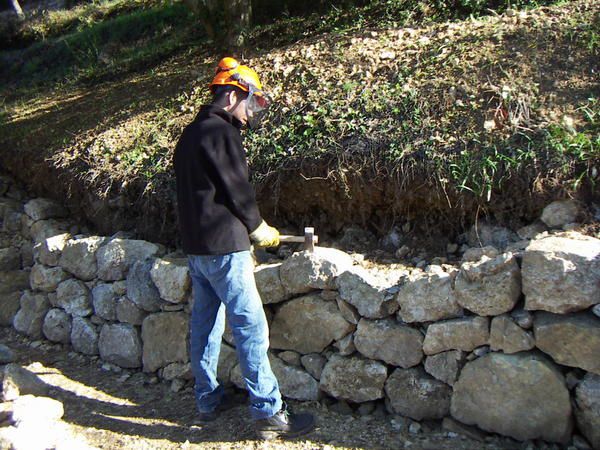 Dans le chantier école, nous apprenons à construire des murs en pierres séchées.