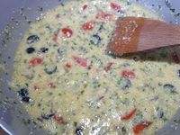 2 - Mettre le four à préchauffer th 6 (180°). Couper les olives noires et vertes, les incorporer à la préparation. Laver, sécher l'origan. Le hacher et l'ajouter aux oeufs battus. Verser le parmesan râpé, mélanger, et terminer en incorporant les pommes de terre tièdes  pelées et coupées en dès. Bien mélanger le tout, saler et poivrer.