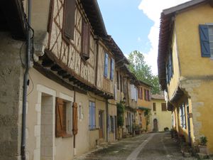  Entrée du village, hautes maisons de pierre, de torchis et de colombage, enroulées autour de l'église.