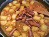 3 - Mouiller au 3/4 avec 20 cl d'eau environ, couvrir et laisser cuire environ 35 mn jusqu'à ce que les pommes de terre soient cuites en surveillant (rajouter un peu d'eau en cours de cuisson si besoin). Couper chaque merguez en 3 morceaux, les incorporer au plat en fin de cuisson, répartir dans le plat. Creuser 4 petits emplacements dans l'ojja et venir y placer les oeufs cassés, laisser cuire jusqu'à ce que les blancs soient bien pris. Saupoudrer de persil (ou coriandre) et servir de suite.