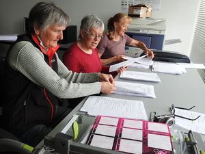 Marie-France devant la photocopieuse ; Annick, Odile et Marina ont classé par étape l'itinéraire.