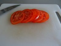 Coupez vos pains. Faites 8 rondelles de tomate puis faites cuire vos steack à la poêle. (les végétals dans une poêle bien sûr!)