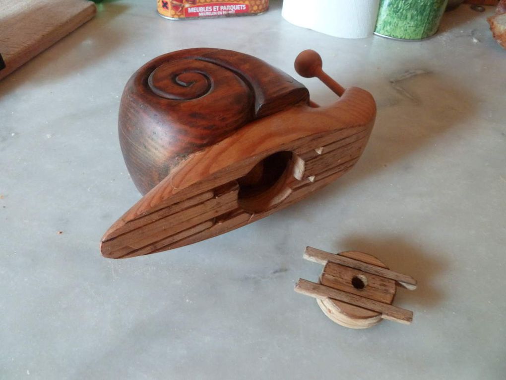 L'escargot tirelire. Bois pin des Landes. Longueur 17cm. C'est la première sculpture que j'ai réalisée en 1987. Nous avions entrepris d'acheter une camionnette à aménager pour nos escapades. Le meilleur moyen de mettre des sous à plats était de faire une tirelire à l'image de notre projet. L'estafette Renault que nous avions acquise et aménagée a été baptisée "l'escargotte". J'ai encore cette pièce chez moi.