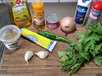 1 - Peler les pommes de terre et les couper en morceaux. Laver, sécher, épépiner les tomates et les couper en morceaux. Tailler le piment vert en petites rondelles, peler et hacher l'oignon , peler l'ail, le dégermer et le passer au presse-ail. Ciseler le persil ou la coriandre.