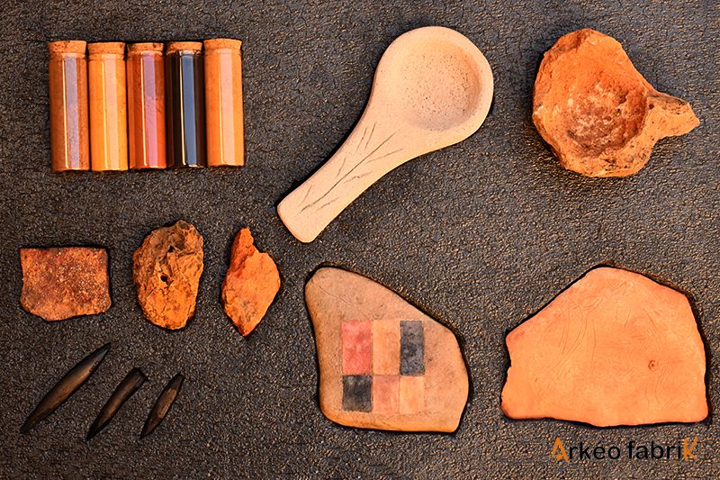 Second volet de la mallette : pigments minéraux bruts et en poudre (ocres), lampe à graisse, godet, plaquette gravée et blason peint.