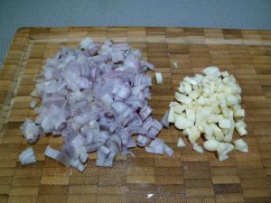 2 - Peler les échalotes et l'ail, dégermer et émincer finement. Laver, couper et épépiner les tomates pour les détailler en petits dés. Mettre le sachet de riz à cuire dans une casserole d'eau bouillante. Nettoyer les champignons et les couper en petits morceaux, faire de même avec les chairs des aubergines.