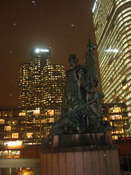 <P><STRONG>Images volées la nuit, dans l'un des quartiers les plus défigurés d'Île de France, la Défense</STRONG>. Des Tours immenses surplombent&nbsp;des sculptures fantomatiques, entourant une arche colorée par des spots rouge et vert. Au milieu d'une place, une écran de télévision géant diffuse des publicités aux travailleurs-passants.</P>
<P><STRONG>Ambiance "Blade Runner" assurée</STRONG>, il ne manquerait plus qu'une musique symphonique macabre pour couronner le tout.&nbsp;Pourtant, <STRO