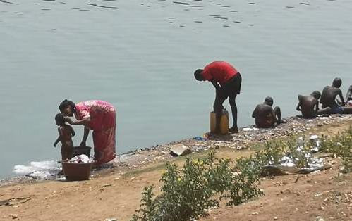 Au bord du fleuve. Une maman lave sa petite fille , les garçons lavent leur linge. Dès 6-7 ans, les enfants gèrent seuls l'entretien de leurs vêtements .