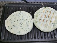 3 - Modeler la pâte en boudin en farinant le plan de travail, et la diviser en 8 parts égales. En faire des boules et les aplatir en conservant une certaine épaisseur (la galette ne doit pas être trop fine). Faire cuire au grill pendant 2 à 3 mn sur chaque face pour qu'elle soit bien dorée. 