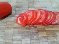 1 - Bien laver et essuyer les pommes de terre sans les éplucher. Verser dans un bol l'huile d'olive, peler et dégermer l'ail, l'écraser au presse-ail et l'incorporer à l'huile. Ajouter le piment (1 cuil.à café), du sel, du poivre et le thym égrainé. Retirer chaque extrémité des pommes de terre et les couper en tranches assez fines et les tomates en rondelles. 