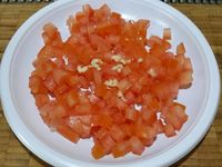 1 -  Mettre l'oeuf à cuire pour 9 mn. Laisser refroidir et écaler. Pendant ce temps, tailler la tomate épépinée en petits dés. Eplucher et dégermer l'ail, le couper finement et l'ajouter à la tomate.