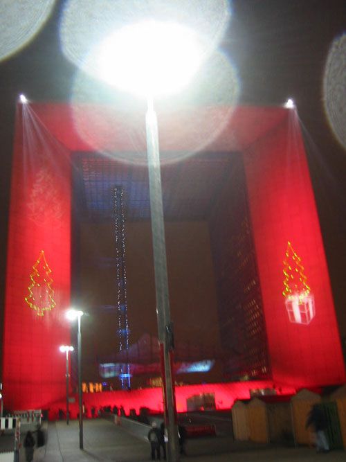 <P><STRONG>Images volées la nuit, dans l'un des quartiers les plus défigurés d'Île de France, la Défense</STRONG>. Des Tours immenses surplombent&nbsp;des sculptures fantomatiques, entourant une arche colorée par des spots rouge et vert. Au milieu d'une place, une écran de télévision géant diffuse des publicités aux travailleurs-passants.</P>
<P><STRONG>Ambiance "Blade Runner" assurée</STRONG>, il ne manquerait plus qu'une musique symphonique macabre pour couronner le tout.&nbsp;Pourtant, <STRO