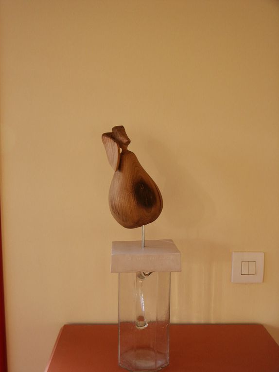 La poire à Ginette. Bois extrait d'une poutre de châtaignier de 200 ans. Hauteur 19cm. Cette poire est en remplacement d'une précédente en Siporex enduit qui a été brisée. Je me suis appliqué à laisser la feuille attachée au fruit par une portion de brindille. La poire est élevée sur socle de pierre calcaire de Pontigny au moyen d'une tige d'aluminium. 