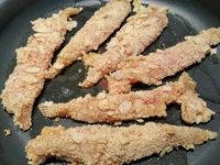 2 - Mettre le riz à cuire (voir temps de cuisson sur le paquet suivant riz choisi). Saler les aiguillettes de poulet sur les 2 faces et les tremper dans l'oeuf battu, bien les rouler ensuite dans le mélange chapelure-amandes-cacahuètes. Verser un filet d'huile d'olive dans une poêle, attendre que l'huile soit bien chaude et faire dorer les aiguillettes 3 mn sur chaque face. Les déposer très rapidement sur du papier absorbant pour éliminer l'excédent d'huile et les disposer ensuite dans un plat creux sur un lit de salade.