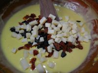 2 -  Découper successivement en petits dès les garnitures choisies, olives noires, tomates séchées, emmental et tomates fraîches épépinées. Les ajouter à la préparation et bien mélanger le tout. Saler et poivrer, votre préparation est terminée !