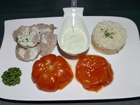 4 - Sur une assiette de service disposer une petite timbale de riz, quelques tranches de filet mignon arrosées de sauce aux graines de sésame et à l'ail confit, 2 moitiés de tomates confites décorées de quelques graines de sésame, une petite coupelle de sauce et un brin de persil. Déguster aussitôt.