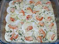 3 - dans un plat à gratin disposer successivement : une couche de pommes de terre à recouvrir avec une partie de la préparation, une couche de courgette sur laquelle vous viendrez verser une nouvelle couche de l'appareil oeuf/crème, répartir ensuite quelques écrevisses, recouvrir d'une couche de pommes de terre avec un peu d'appareil, puis à nouveau des rondelles de courgette parsemées d'écrevisses avec un peu de préparation, finir enfin avec une dernière couche de pommes de terre et le reste de l'appareil. Garder quelques écrevisses pour la décoration après cuisson du plat. Enfourner pour 40 à 45 m th 6,5 (200°) en surveillant. Le gratin doit être bien doré et fondant.  