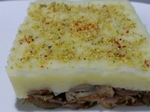 3 - Placer des emporte-pièces sur des assiette de service chaudes. Déposer une bonne couche d'effiloché de canard , bien tasser. Rajouter une couche de purée, égaliser et tasser à nouveau. Retirer délicatement les emporte-pièces. Avant de décorer vous assurer de la bonne température de vos plats, dans le cas contraire les repasser rapidement au four ou au micro onde. Saupoudrer les parmentiers de chapelure (noix de cajou et pistaches finement mixées), d'un peu de piment d'Espelette, et d'un brin de persil.