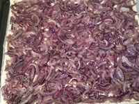 2 - Répartir les oignons en une couche régulière sur la pâte, poivrer et saler très légèrement, rajouter les rondelles d'olives puis le thym lavé séché et émietté. Poser vos anchois sur du papier absorbant pour retirer l'excédent d'huile. En réserver un entier pour la décoration et couper les autres en petits morceaux à répartir sur la pissaladière. Enfourner la pissaladière pour 20 mn environ en surveillant (th 6), puis la sortir et disposer le reste des ingrédients : noix de pétoncles, crevettes grises, gambas et enfourner à nouveau pour 5 mn. Servir aussitôt entière à partager ou découper des portions individuelles à présenter au plat